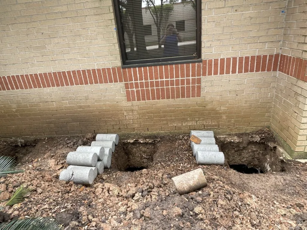 Concrete pilings beside a commercial building excavation