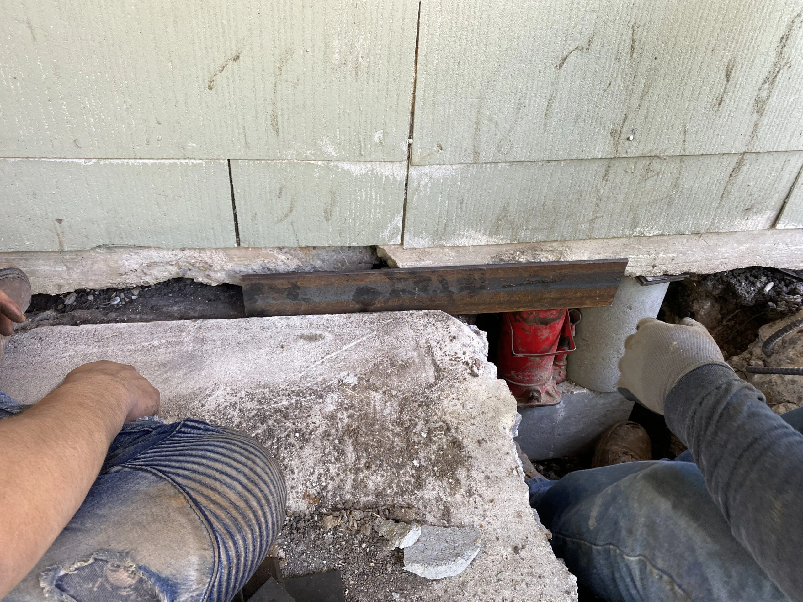 Worker beneath a raised foundation wall